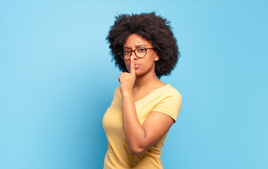  asking for silence and quiet, gesturing with finger in front of mouth, saying shh or keeping a...