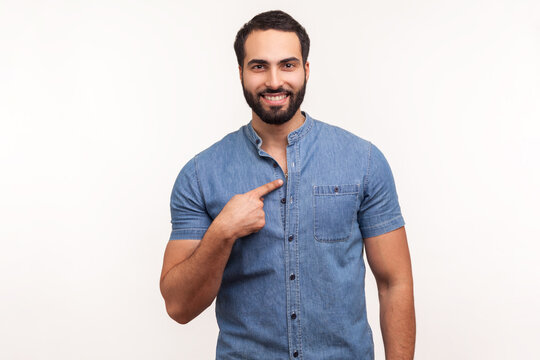 Handsome Bearded Man Pointing Finger On Itself Looking At Camera With Toothy Smile, Proud Of His Success And Achievements. Indoor Studio Shot Isolated On White Background