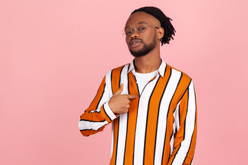 Proud self confident african man with dreadlocks in stylish shirt egoistically pointing finger on...