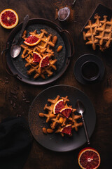 Belgian waffles with orange on a plate, flat lay
