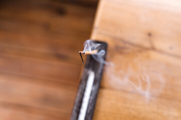 Smoking incense stick on a stand close-up