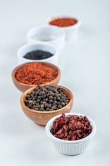 Many bowls of spices on a white background