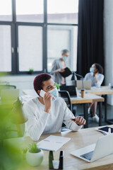 African american businessman talking on smartphone in office