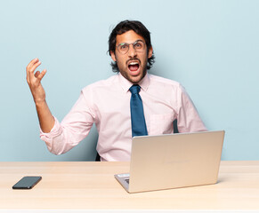 young handsome indian man looking angry, annoyed and frustrated screaming wtf or what’s wrong...