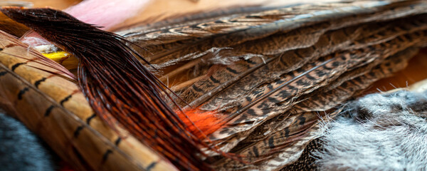 Fishing fly tying materials on a wooden table