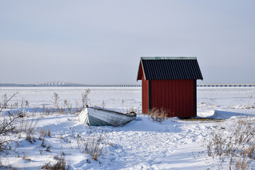 Old rowing boat by a red fishing shed
