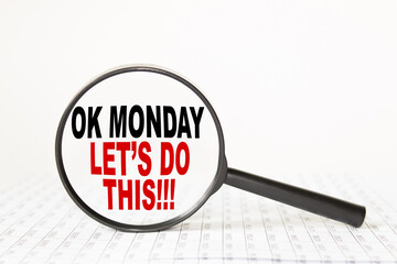 words OK MONDAY LET'S DO THIS in a magnifying glass on a white background. business concept