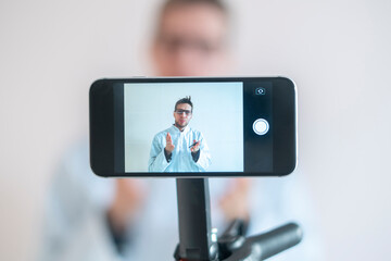 doctor reading the lecture to the stdents online using a phone as a webcam