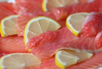 slices of salty red fish with lemon close up