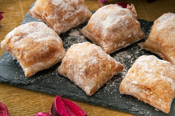 Cakes with icing sugar on black slate plate