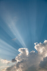 A sky with white clouds and beautiful sunbeams passing through the clouds. The magical beauty of...