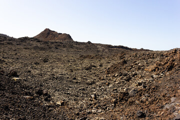 Black rocks with volcano on top at Timanfaya National Park. Volcanic natural landscape in Lanzarote island. Tourist attraction, travel destination concepts
