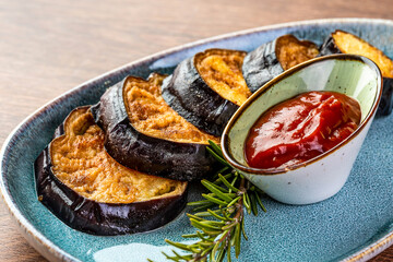 Fried eggplant and tomato sauce on a blue plate
