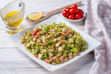 .Traditional Lebanese salad tabouli tabule with wheat, herbs, tomatoes, mint and lemon.