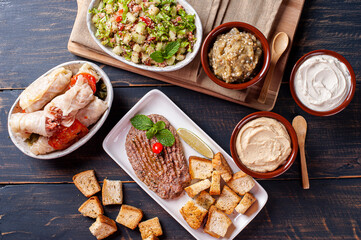 Meze is an oriental set of appetizers served in small bowls with babaganush, curd, hummus and kibbeh
