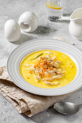 Chicken breast in a creamy broth. Chicken with vegetables and cream. Chicken soup in a bowl on the light gray kitchen table