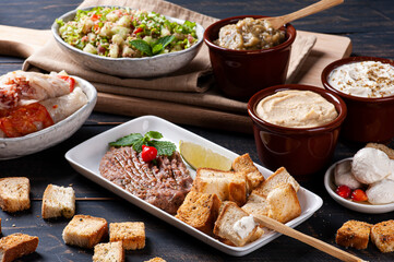 
Raw kibbeh, toast with Syrian curd, humus and babaganush in the background