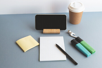 smartphone, wireless headphones, notepad, markers, coffee cup, online education concept 