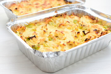 Baked chicken and mushroom cannelloni, bathed in cream in cheese sauce gratin on white wooden background