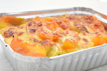 Baked chicken and mushroom cannelloni, bathed in cream in cheese sauce gratin on white wooden background