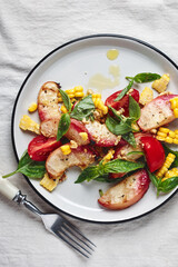 Salad with grilled peaches, corn,  tomatoes and basil.