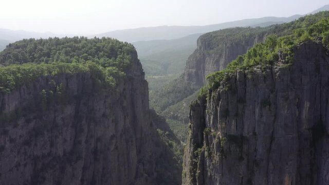 A man are sitting on the edge of the Tazy canyon in National Park on Manavgat, Antalya, Turkey. Aerial view 4K.