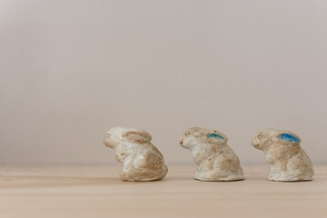 Vintage ceramic bunny rabbits lined up on a simple wooden shelf; minimalist Easter decor