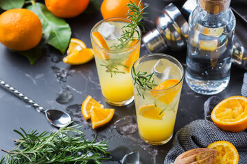 Hard seltzer cocktail with orange, rosemary and bartenders accessories