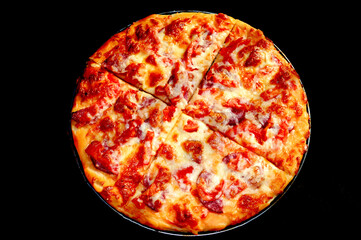round baked tasty pizza on a black background - obrazy, fototapety, plakaty