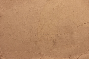 The texture of old stained, faded cardboard. Cardboard sheet with torn, frayed edges.