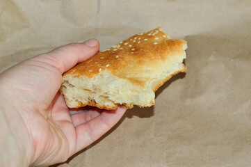 close-up - a piece of flatbread in female hand on the background of a paper bag