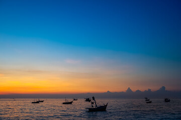 Fototapeta na wymiar silhouette of fishing boats against sunset