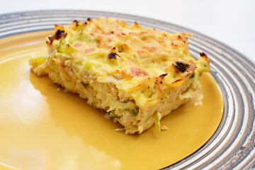 Baked chicken and mushroom cannelloni, bathed in cream in cheese sauce gratin on white wooden background