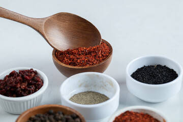 Many bowls of spices on a white background