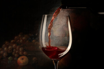 glass with red wine on the dark background