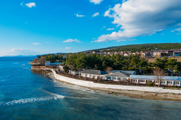 Aerial view of Divnomorskoe small sea resort town on Black Sea coast, beautiful seascape in sunny day.