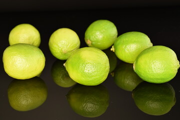 Several ripe limes, close up, on a black background.
