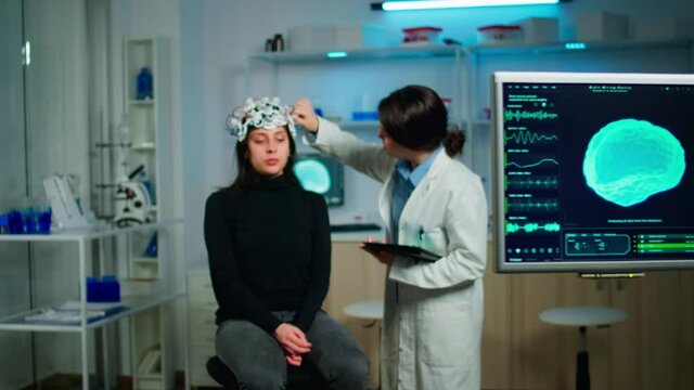 Doctor analysing brain scan using tablet, examining evolution of disease working in neurological laboratory. Monitoring nervous system functions using high tech in technologically advanced lab office