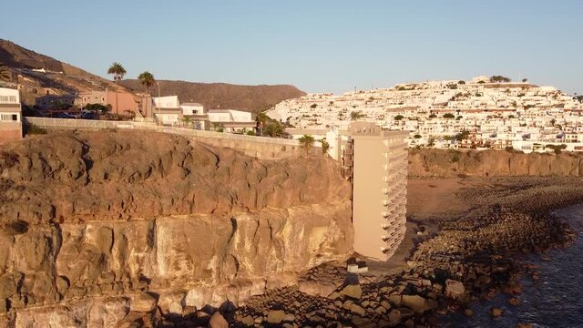 Aerial view with drone of urbanization of small white houses on a cliff by the sea. Gran Canaria. Arguineguin.