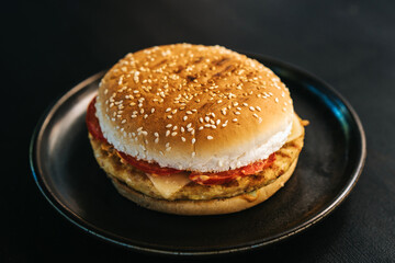Cheesburger with grilled beef and bacon on black plate