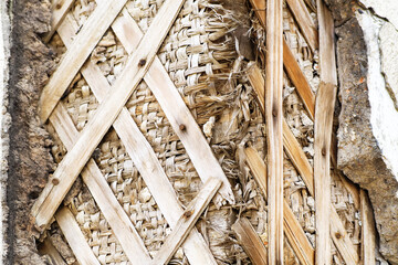 Old building technology, building background. Old partially collapsed clay wall, shingle lathing