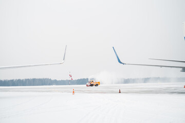 A snowplow clearing snow from the runway.