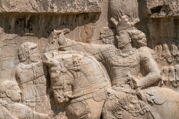 Murals of Necropolis, king burial site of ancient Persia. King on his horse carved into sandstone rock wall.