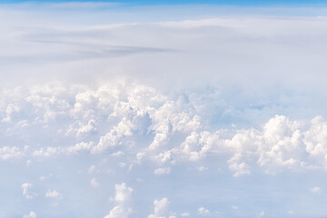 Fototapeta na wymiar Above view of sky cloudscape with fluffy clouds and bright soft sunny sunlight aerial view of Europe from airplane