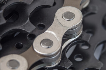 Black teeth of a bicycle cassette and chain links in a macro photo. Selective focus