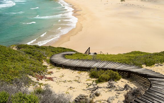 Winding wooden path going down a hill and leading to the beach in Robberg Nature Reserve, Plettenberg Bay, South Africa.