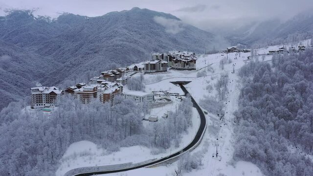 panorama of Rosa Khutor on a frosty winter day. Fly above winter snow covered trees.