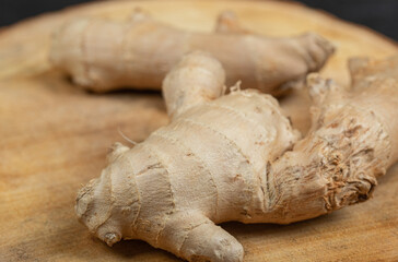 Fresh gingers rhizome or root on a wooden board