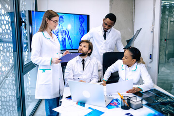 Fototapeta premium International team of young doctors discussing computed tomograp