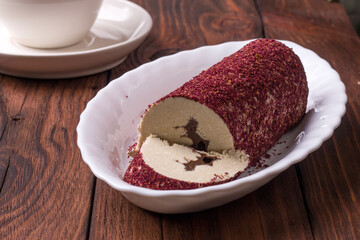 Eastern sweet halva with chocolate and rose powder on wooden background.